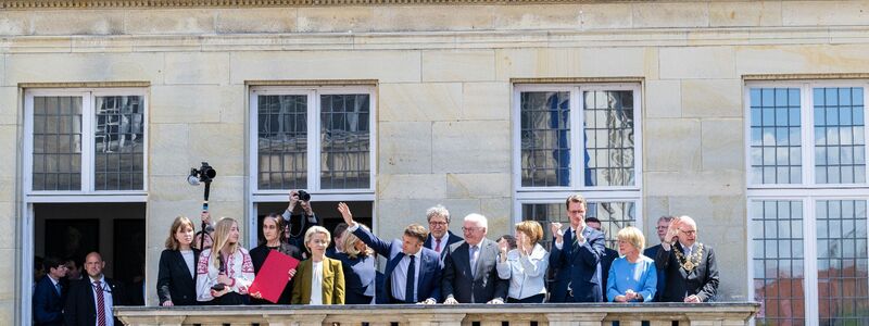 Der französische Präsident Emmanuel Macron winkt der Menge vom Balkon des Stadtweinhauses zu. - Foto: Guido Kirchner/dpa