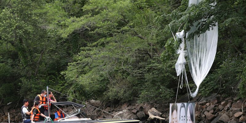 Südkoreanische Polizeibeamte sammeln einen hängengebliebenen Ballon ein (Archivbild). - Foto: Yang Ji-Woong/Yonhap/dpa
