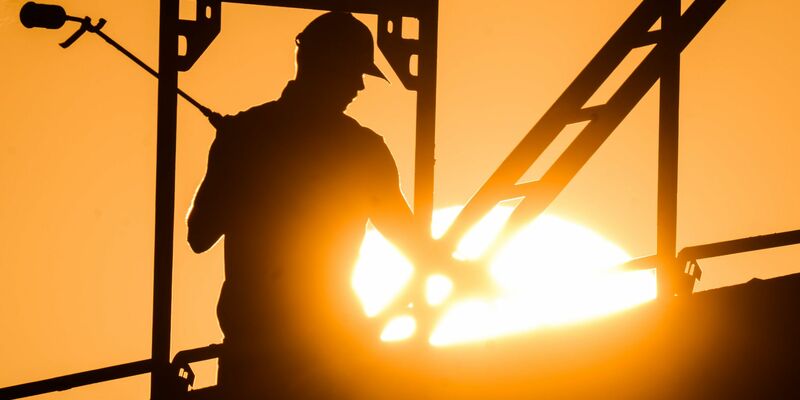 Ein Bauarbeiter beim Bau eines Mehrfamilienhauses im Neubaugebiet Kronsrode, Niedersachsen. - Foto: Julian Stratenschulte/dpa