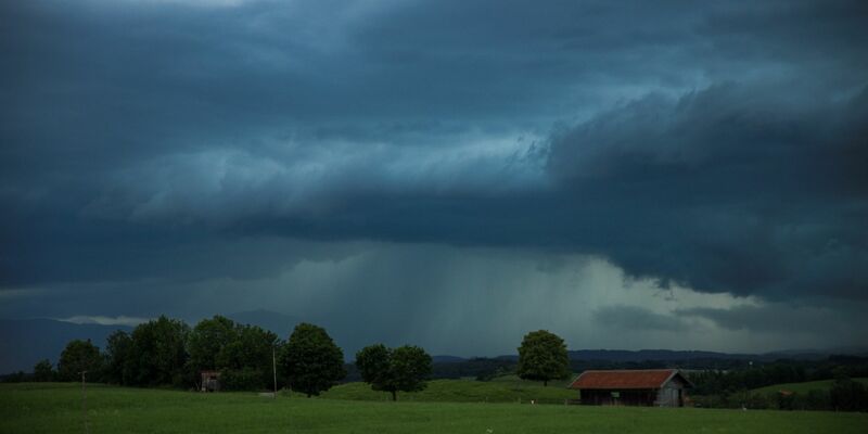 Dunkle Gewitterwolken hängen über der Landschaft in Penzberg (Oberbayern). Der Deutsche Wetterdienst hat vor Unwettern in weiten Teilen Süddeutschlands gewarnt. - Foto: Alexander Wolf/dpa
