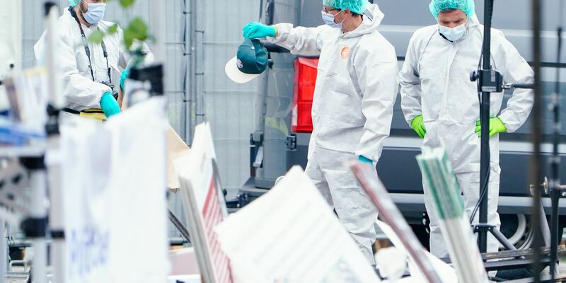 Mitarbeiter der Spurensicherung am Tatort. - Foto: Uwe Anspach/dpa