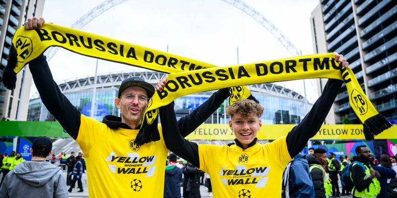 Zwei Fans von Borussia Dortmund stehen mit einem BVB-Fan-Schal vor dem Wembley-Stadion. - Foto: Tom Weller/dpa