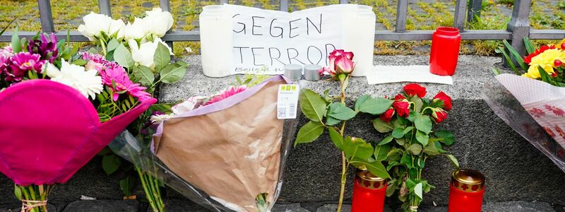 Kerzen, Blumen und ein Blatt Papier mit der Aufschrift «Gegen Terror» stehen am Tatort auf dem Mannheimer Marktplatz. - Foto: Uwe Anspach/dpa