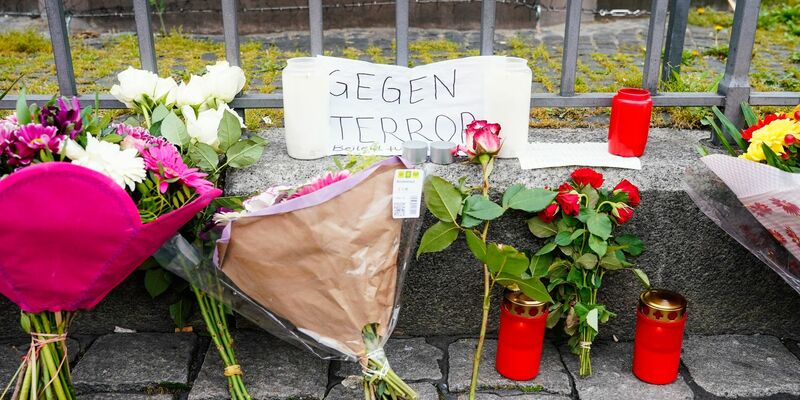 Mitarbeiter der Spurensicherung stehen auf dem Marktplatz hinter einem zertrümmerten Stand. - Foto: Uwe Anspach/dpa