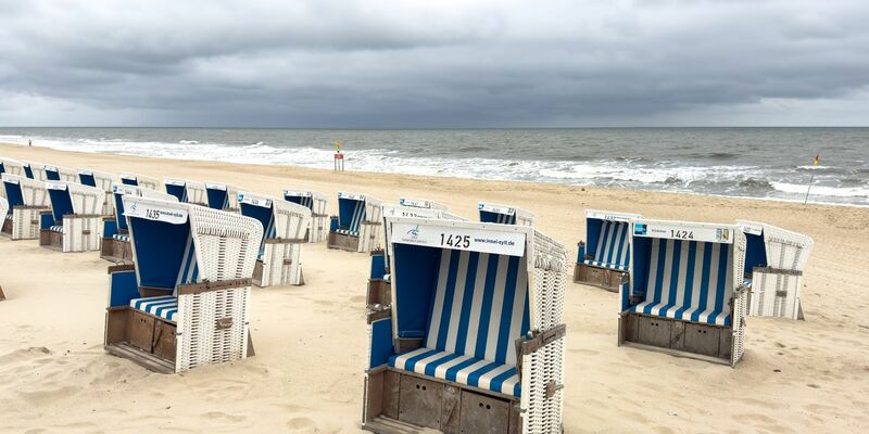 Strandkörbe bei bewölktem Himmel und Temperaturen um 15 Grad Celsius am Strand von Westerland. - Foto: Bodo Marks/dpa
