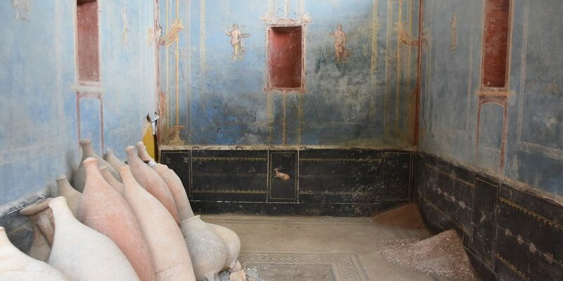 Ein Raum mit blauen Wänden und gemalten weiblichen Figuren ist in Pompeji freigelegt worden. - Foto: Archäologiepark Pompeji/dpa