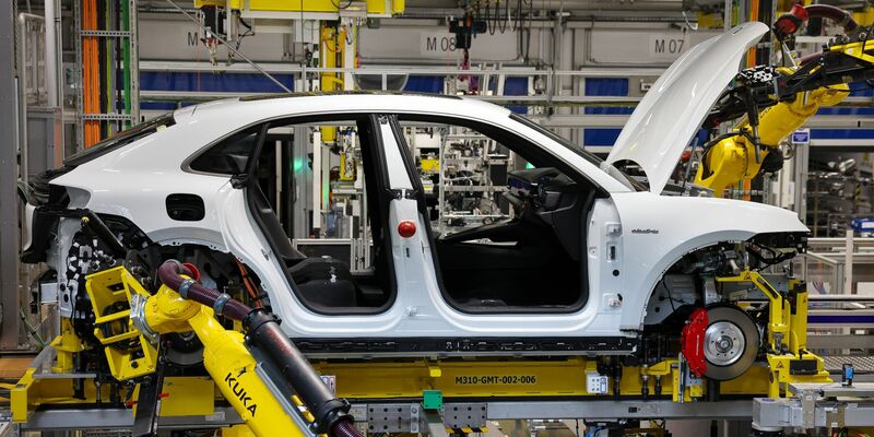 Industrieroboter arbeiten an einem vollelektrischen Porsche Macan. - Foto: Jan Woitas/dpa