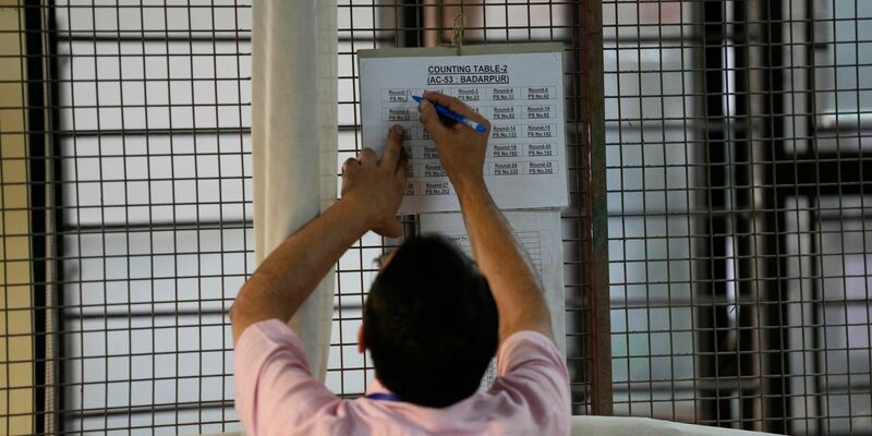 Ein Wahlhelfer markiert eine Tabelle nach der ersten Runde der Stimmenauszählung in einem Auszählungszentrum in Neu-Delhi. - Foto: Manish Swarup/AP/dpa