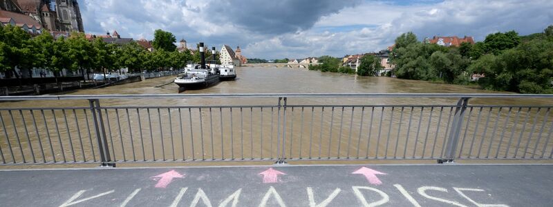 Jemand hat in Regensburg das Wort «Klimakrise» auf eine Brücke über der Donau geschrieben. - Foto: Sven Hoppe/dpa