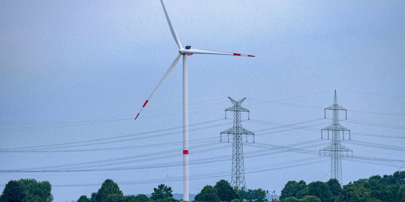 Eine Windkraftanlage und Hochspannungsleitungen in NRW. - Foto: Thomas Banneyer/dpa