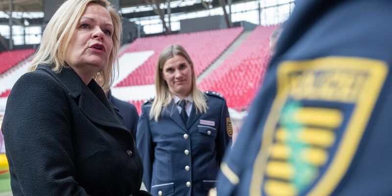 Nancy Faeser (SPD, l), Bundesinnenministerin, unterhält sich in der Leipziger Arena mit Vertretern der Polizei. - Foto: Hendrik Schmidt/dpa