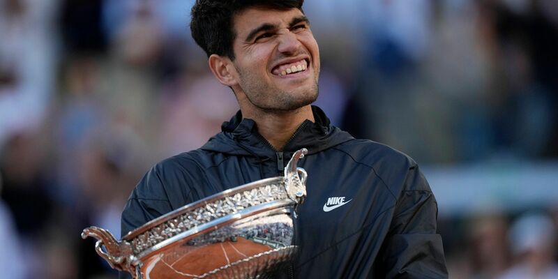 Carlos Alcaraz feiert mit der Trophäe nach seinem Sieg. - Foto: Thibault Camus/AP