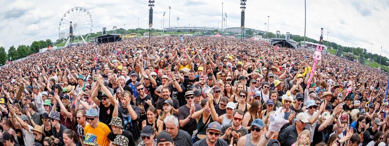 Zahlreiche Zuschauer verfolgen ein Konzert beim Open-Air-Festival Rock im Park. - Foto: Daniel Karmann/dpa