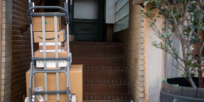 Gestapelte Pakete in einem Hauseingang. Das Postgesetz ist in seinen wesentlichen Teilen schon seit 1998 gültig. - Foto: Sebastian Gollnow/dpa