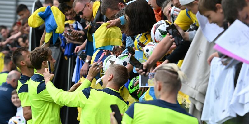 Die ukrainischen Nationalspieler geben nach dem öffentlichen Training Autogramme. - Foto: Arne Dedert/dpa