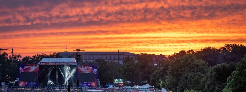 Der Abendhimmel leuchtet über dem Festival-Gelände beim Open-Air-Festival Rock im Park. - Foto: Daniel Karmann/dpa