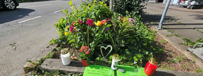 Blumen und Grablichter sind an der Unfallstelle aufgestellt worden. - Foto: Andreas Rosar/dpa