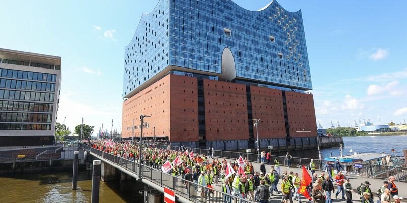 Streikende Hafenarbeiter ziehen bei einer Demonstration an der Hamburger Elbphilharmonie entlang. - Foto: Bodo Marks/dpa