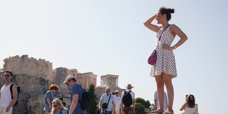 Touristen auf dem Aeropagous-Hügel vor der antiken Akropolis im Zentrum Athens. - Foto: Petros Giannakouris/AP