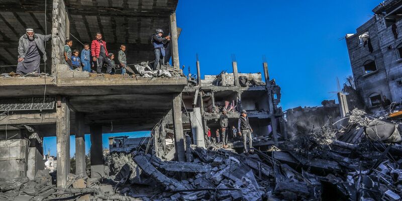 Palästinenser inspizieren die Schäden nach einem israelischen Luftangriff in der Stadt Rafah. Nach dem Kriegsrecht müssen zivile Einrichtungen bei Angriffen möglichst verschont werden. - Foto: Abed Rahim Khatib/dpa