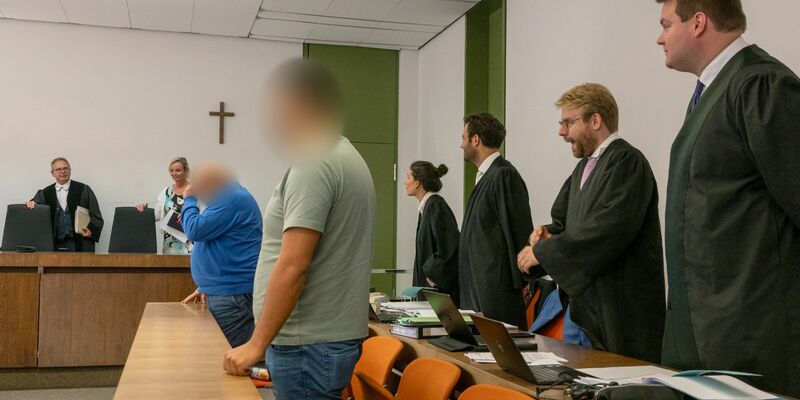 Richter Martin Hofmann (l.) sowie die beiden Angeklagten (vorne) zum Auftakt des Prozesses. - Foto: Peter Kneffel/dpa