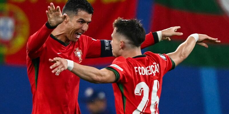 Superstar Cristiano Ronaldo (l) feiert den Torschützen Francisco Conceição. - Foto: Hendrik Schmidt/dpa