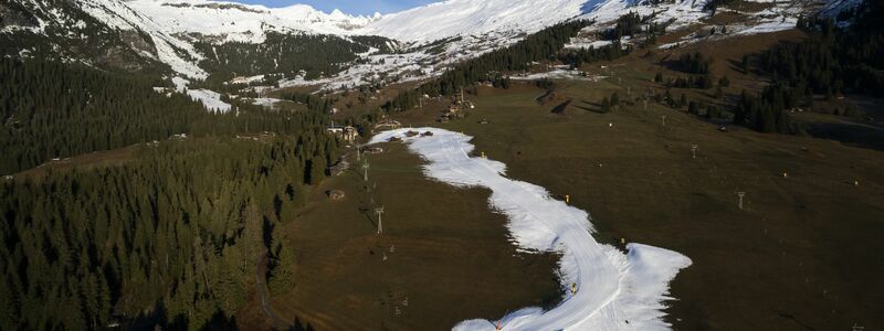 Blick auf eine Talabfahrt aus Kunstschnee. Viele Urlauber fahren zum Skifahren oder zum Wandern in die Schweiz (Archivbild). - Foto: Gian Ehrenzeller/Keystone/dpa