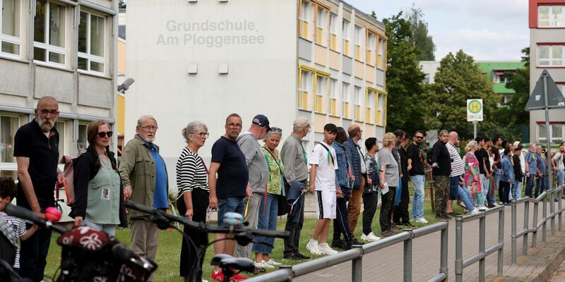 Die Veranstalter sprachen von rund 500 Teilnehmern, die sich mit bunten Bändern zu einer Kette verbunden hatten. - Foto: Bernd Wüstneck/dpa