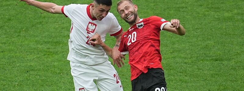 Polens Bartosz Slisz (l) im Kopfballduell mit dem Österreicher Konrad Laimer. - Foto: Michael Kappeler/dpa