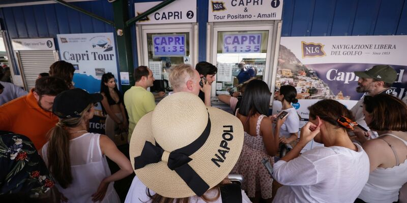 Reisende drängen sich vor Ticket-Schaltern am Molo Beverello für die Fähren, die unter anderem nach Capri fahren. Touristen dürfen nun wieder auf die Insel. - Foto: ---/IPA via ZUMA Press/dpa