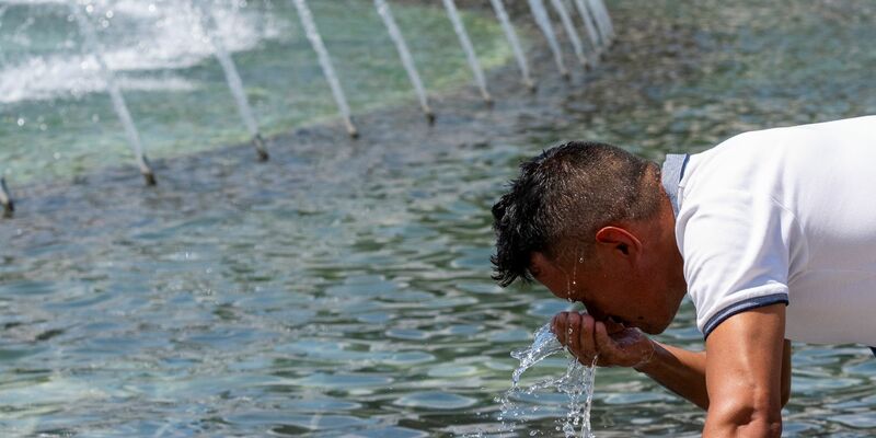 Die Hitze in Teilen der USA ist unerträglich. Da hilft nur eine kleine Abkühlung am Brunnen. - Foto: Alex Brandon/AP