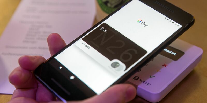 Ein Gast demonstriert mit einem Smartphone und der App in einem Cafe das Bezahlen mit dem Handy. - Foto: Jens Büttner/dpa-Zentralbild/dpa