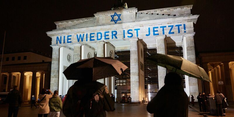 Der Schriftzug «Nie wieder ist jetzt» wird zum 85. Jahrestag der Pogromnacht an das Brandenburger Tor projiziert (Archivbild). - Foto: Jörg Carstensen/dpa