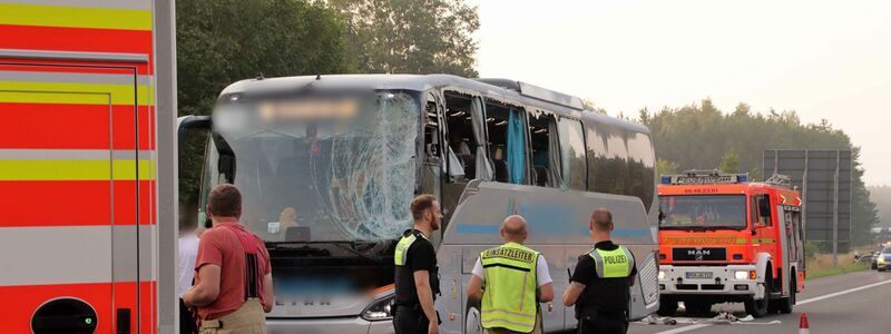 Rettungskräfte stehen neben dem beschädigten Reisebus auf der Autobahn 24. - Foto: SWM DV Studio
Ralf Drefin/dpa