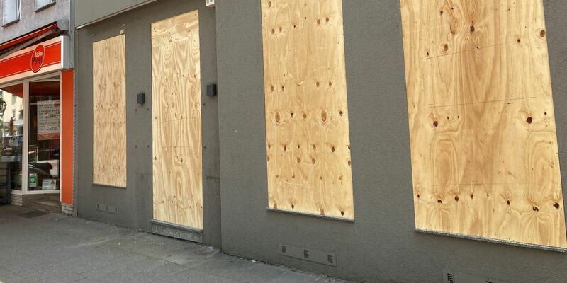 Ein Geschäft hat aus Sorge vor Ausschreitungen Bretter vor den Schaufenstern angebracht. - Foto: Marc Herwig/dpa