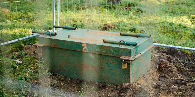 Eine Kampfmittelaufbewahrungskiste in einem abgesperrten Bereich des Waldes. - Foto: Annette Riedl/dpa