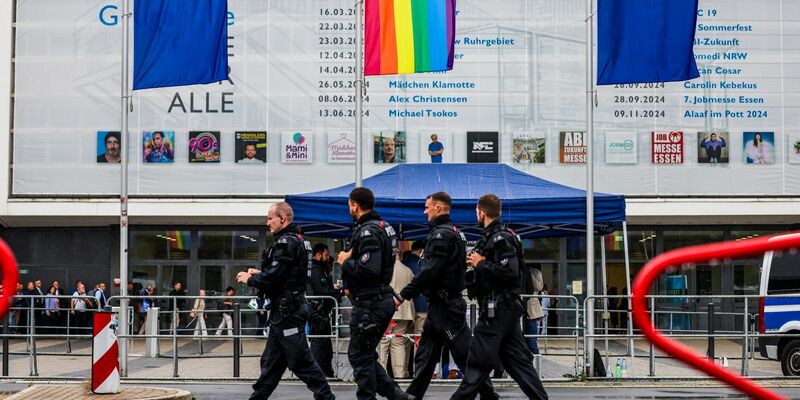 Polizeibeamte laufen im Regen an der Essener Grugahalle vorbei, wo der AfD-Parteitag stattfindet. - Foto: --/dpa