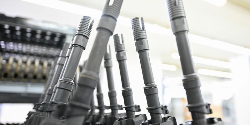 In einer Produktionshalle des Waffenherstellers Heckler & Koch in Oberndorf stehen fertige Sturmgewehre vom Typ HK416 aufgereiht. - Foto: Bernd Weißbrod/dpa