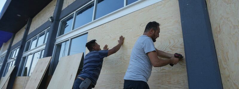 Mitarbeiter eines Möbelhauses in Mexiko verschalen die Fenster zum Schutz vor dem erwarteten Hurrikan «Beryl». - Foto: Fernando Llano/AP