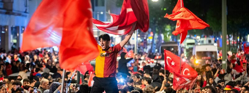 Türkische Fans feiern den Sieg im EM-Achtelfinale am Berliner Breitscheidplatz mit Pyrotechnik. - Foto: Christoph Soeder/dpa