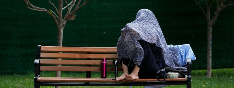 Eine Frau in China schützt sich mit einem Tuch vor der Sonne. - Foto: Andy Wong/AP