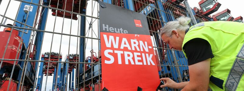 Ein Streikender hängt ein Plakat am Hamburger Hafen auf. (Archivfoto) - Foto: Bodo Marks/dpa