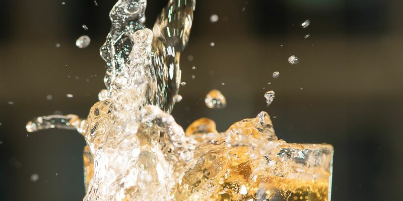 ILLUSTRATION: Apfelschorle spritzt aus einem Glas.  - Foto: Robert Günther/dpa-tmn/dpa