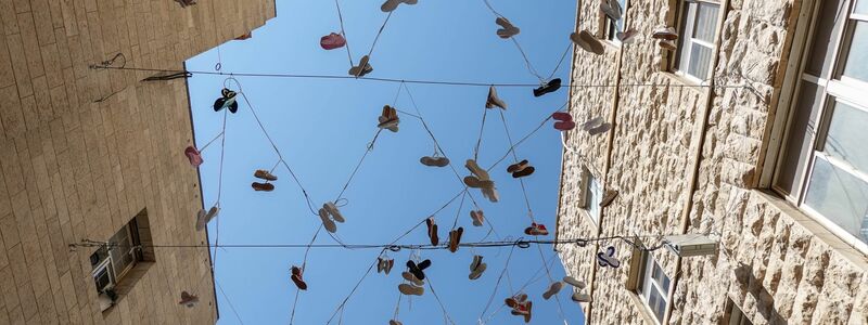 120 Paar Schuhe, als Installation in der Jerusalemer Innenstadt aufgehängt, erinnern an das Los der israelischen Geiseln in der Gewalt der Hamas.  - Foto: Nir Alon/ZUMA Press Wire/dpa