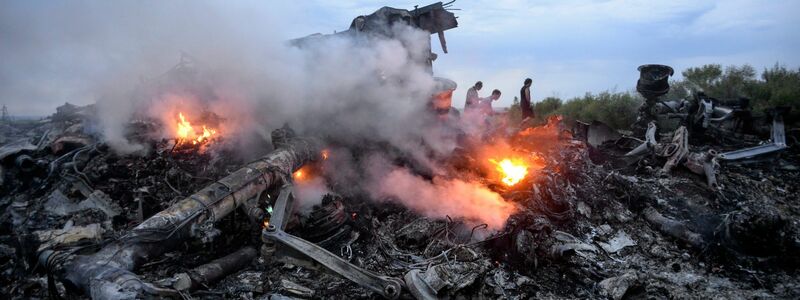 Brennende Trümmerteile der abgeschossenen Boeing 777 (Archivbild) - Foto: Alyona Zykina/epa/dpa