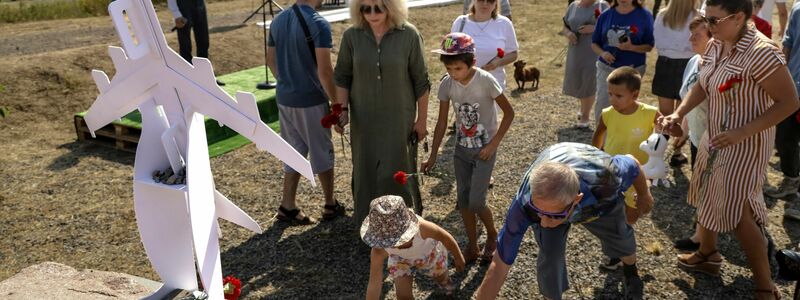 Menschen gedenken der Opfer an der Absturzstelle bei Hrabowe in der Ostukraine. - Foto: Uncredited/AP/dpa