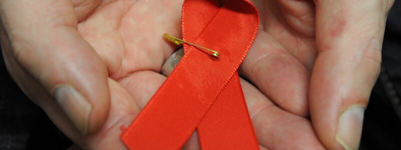 Dir rote Schleife ist ein Symbol der Solidarität mit HIV-Positiven und Aids-Kranken.(Archivbild) - Foto: Arne Dedert/dpa