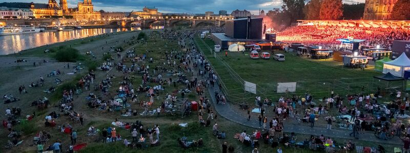 Von den Elbwiesen um das abgegrenzte Konzertgelände herum verfolgen Fans Kaisers Auftakt bei der «Kaisermania» (Archivfoto von 2023) - Foto: Matthias Rietschel/dpa-Zentralbild/dpa