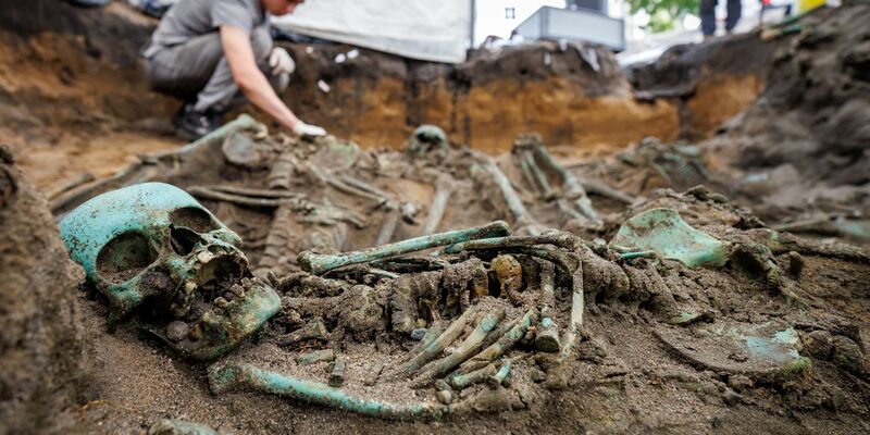 Bis zu eineinhalb Meter tief müssen die Fachleute graben, um alle Toten freizulegen.  - Foto: Daniel Karmann/dpa