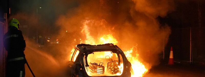 Bei den Krawallen wurde ein Polizeiauto angezündet. - Foto: Owen Humphreys/PA Wire/dpa